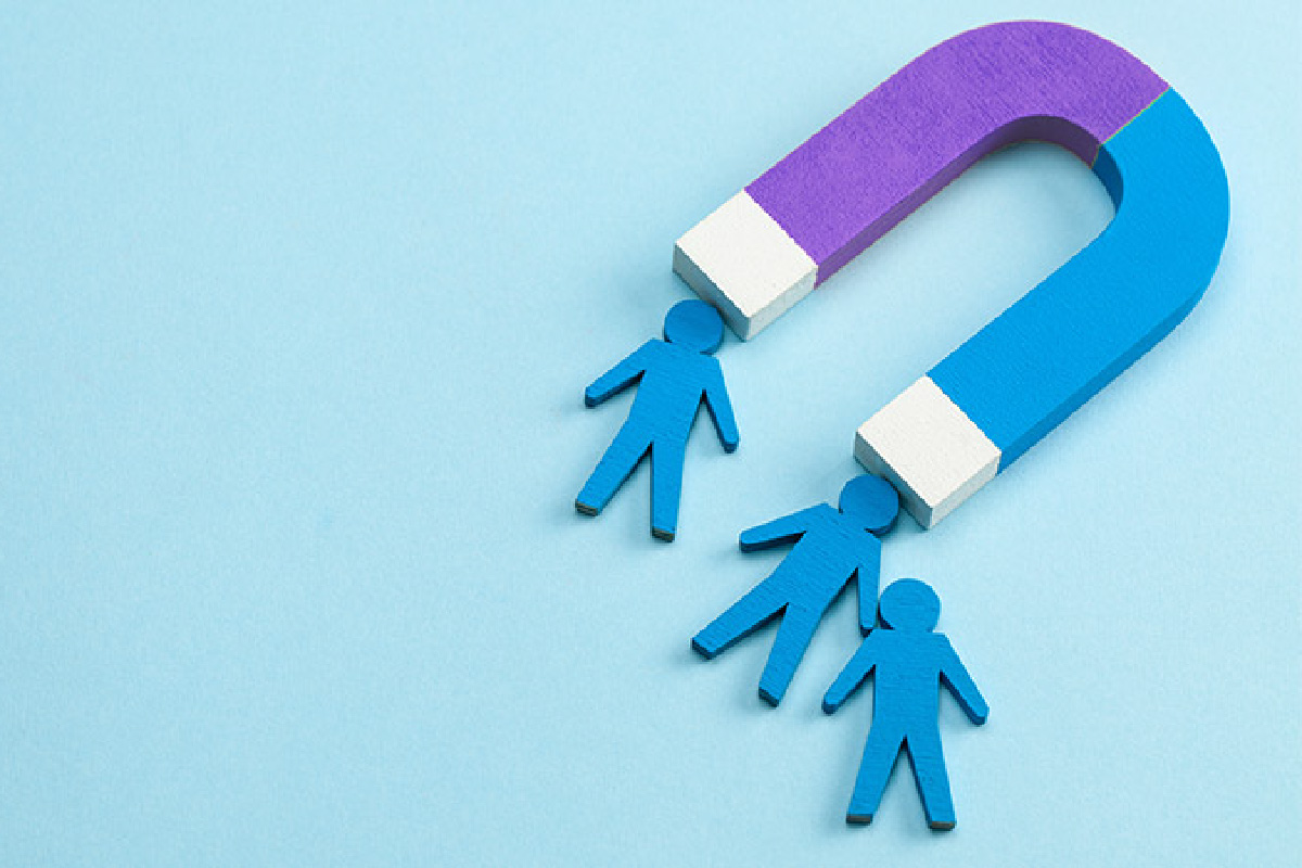 Colorful magnet attracting wooden human icons, symbolizing effective lead assignment and improved lead distribution strategies.