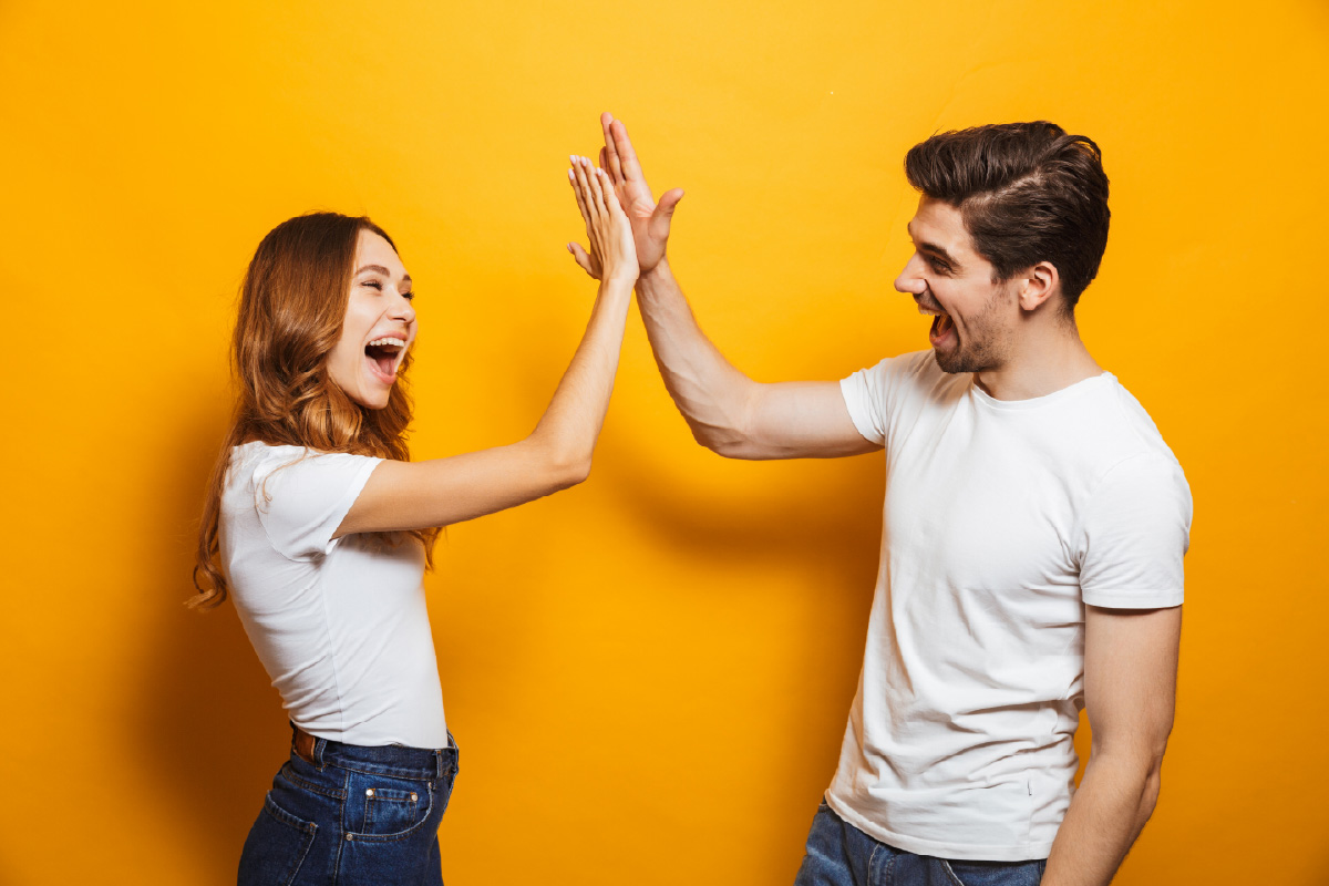 Two colleagues high-fiving, symbolizing the efficiency and successful automation achieved with effective Salesforce assignment rules.